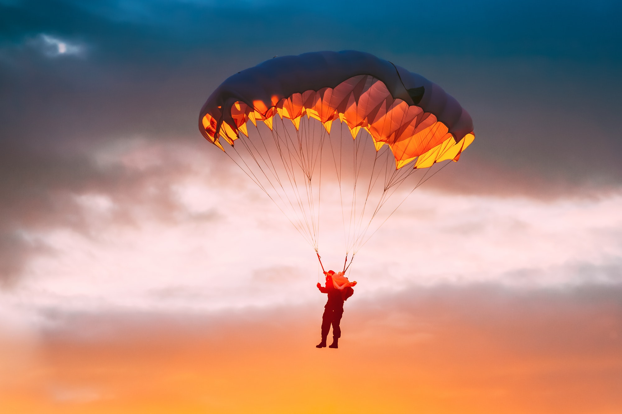 Skydiver On Colorful Parachute In Sunny Sky